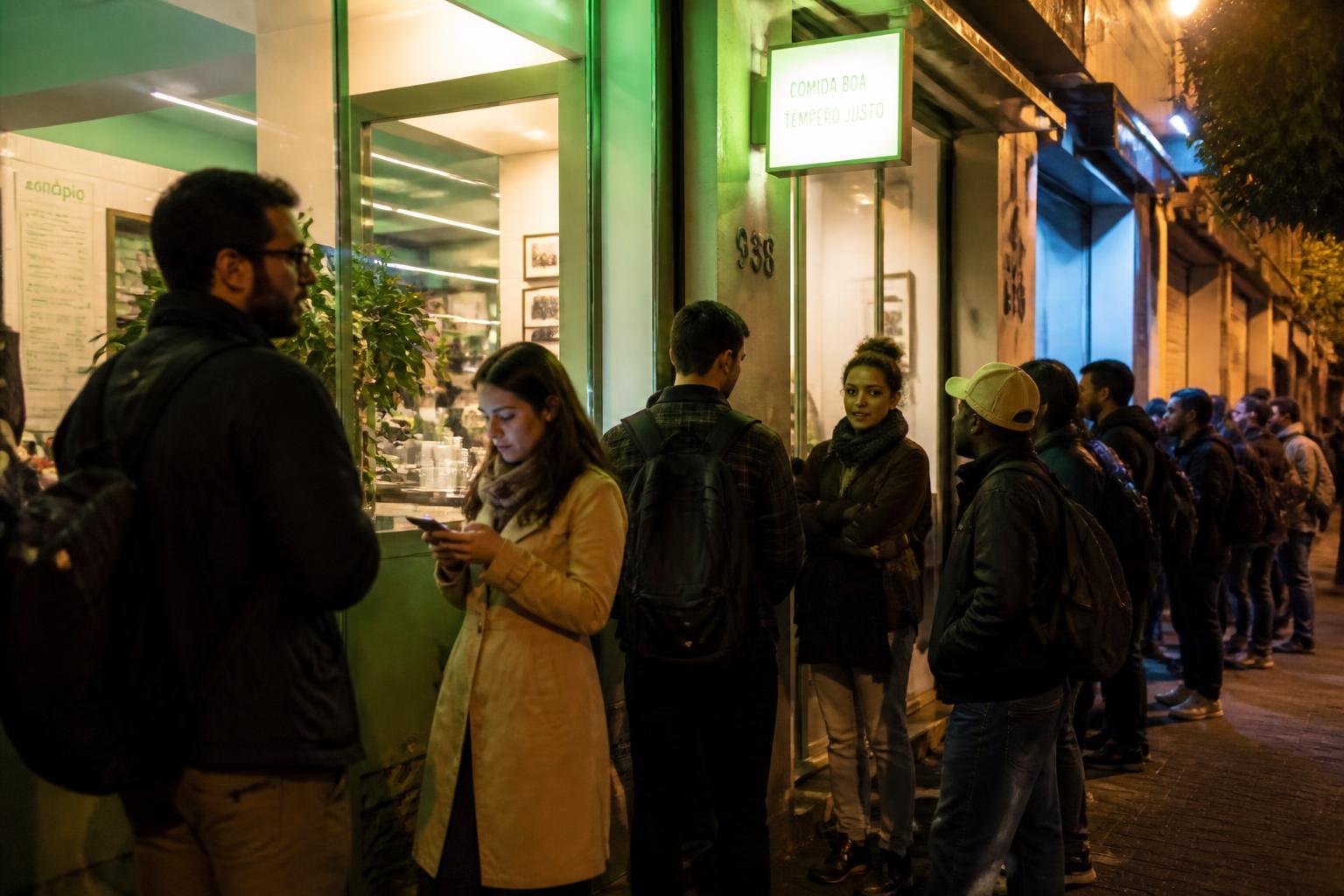 Restaurante movimentado à noite com fila organizada